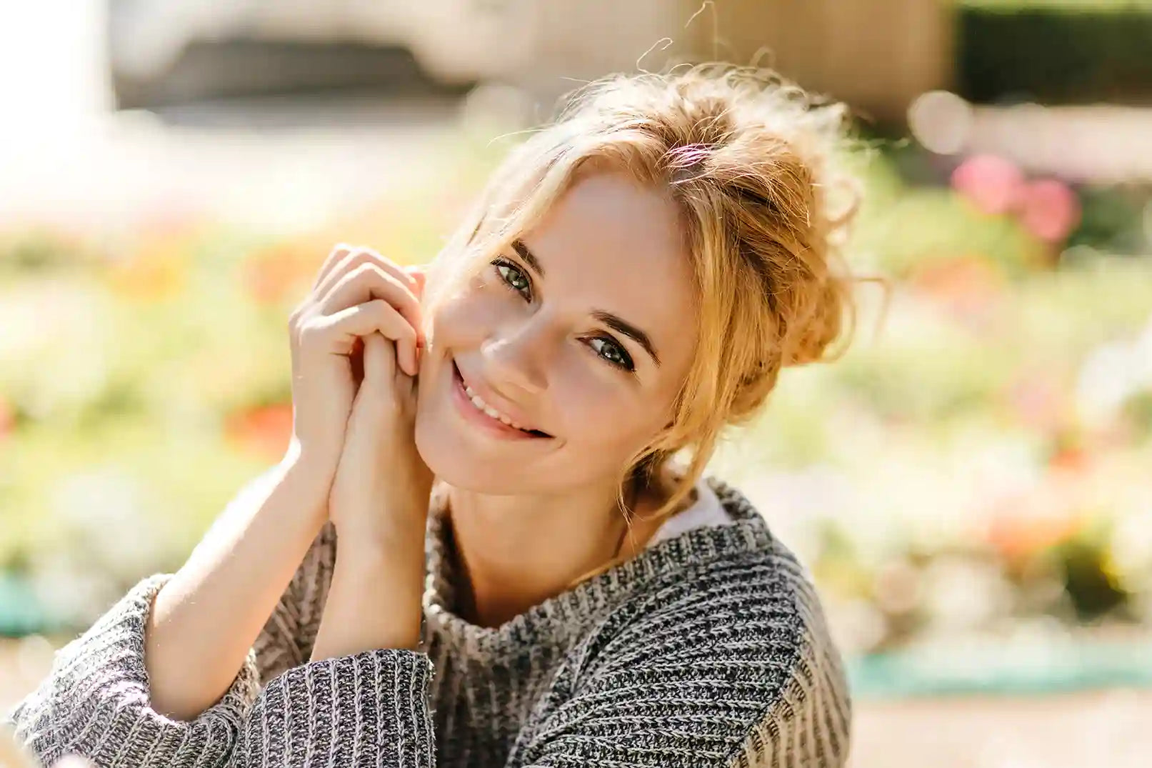 Portrait of a green-eyed blond woman outdoors and smiling into camera